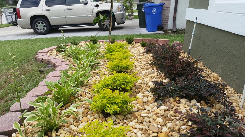Inspiration for a small modern front yard full sun formal garden in Orlando with a container garden and gravel.
