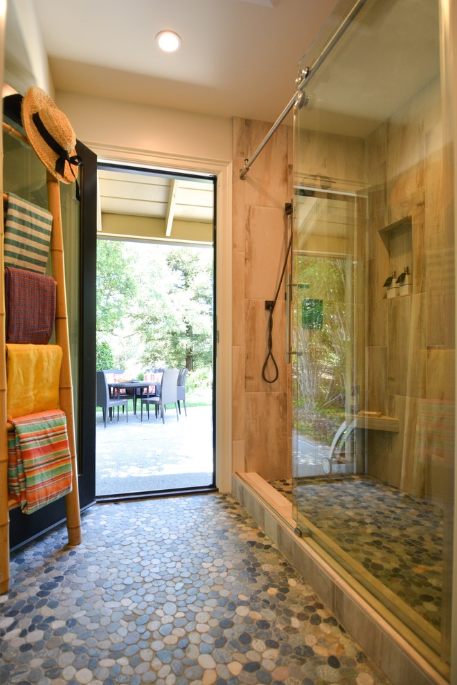 This is an example of a mid-sized beach style 3/4 bathroom in San Francisco with flat-panel cabinets, grey cabinets, an alcove shower, a wall-mount toilet, green tile, porcelain tile, beige walls, pebble tile floors, a trough sink, solid surface benchtops, green floor and a sliding shower screen.