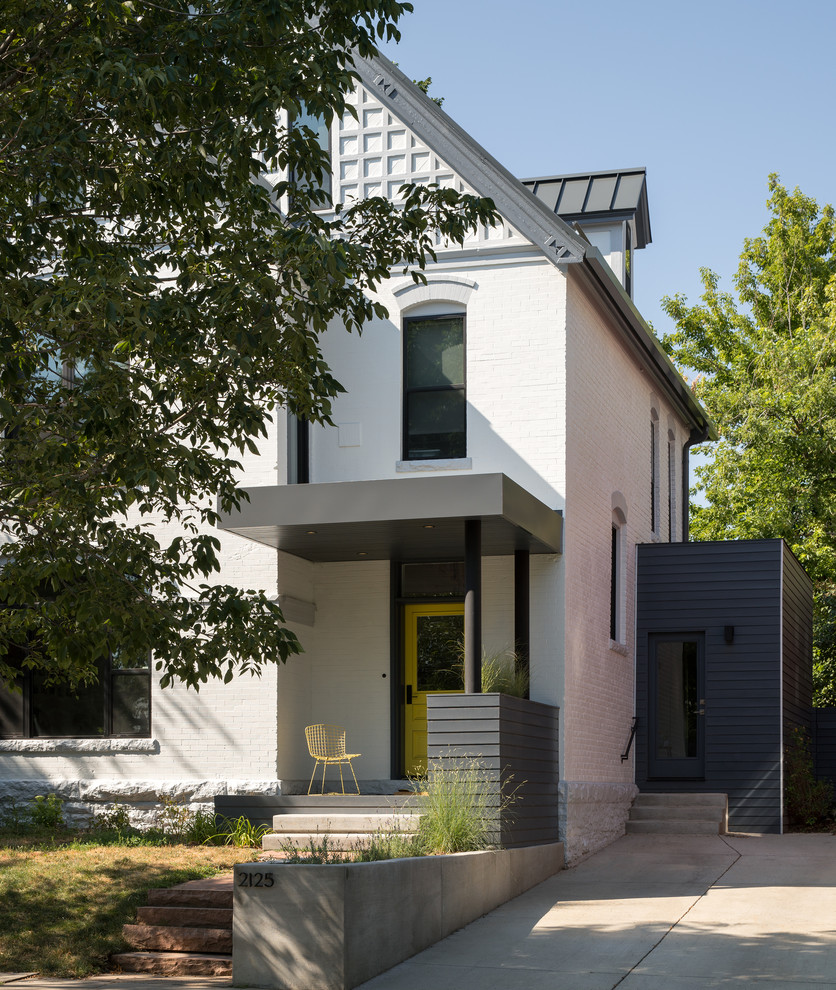 Mid-sized contemporary three-storey stucco white house exterior in Denver with a gable roof and a metal roof.