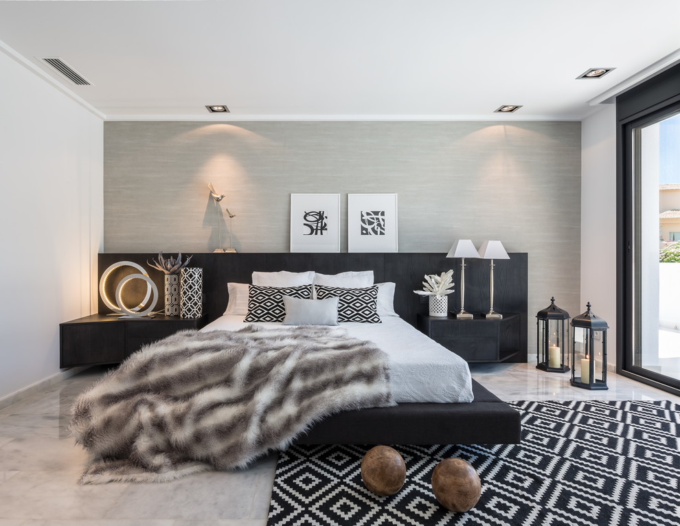 Photo of a large contemporary master bedroom in Madrid with grey walls, marble floors and no fireplace.