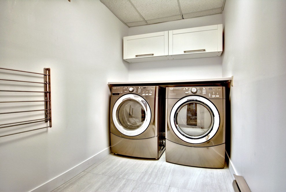 Inspiration for a small contemporary single-wall dedicated laundry room in Montreal with shaker cabinets, laminate benchtops and a side-by-side washer and dryer.