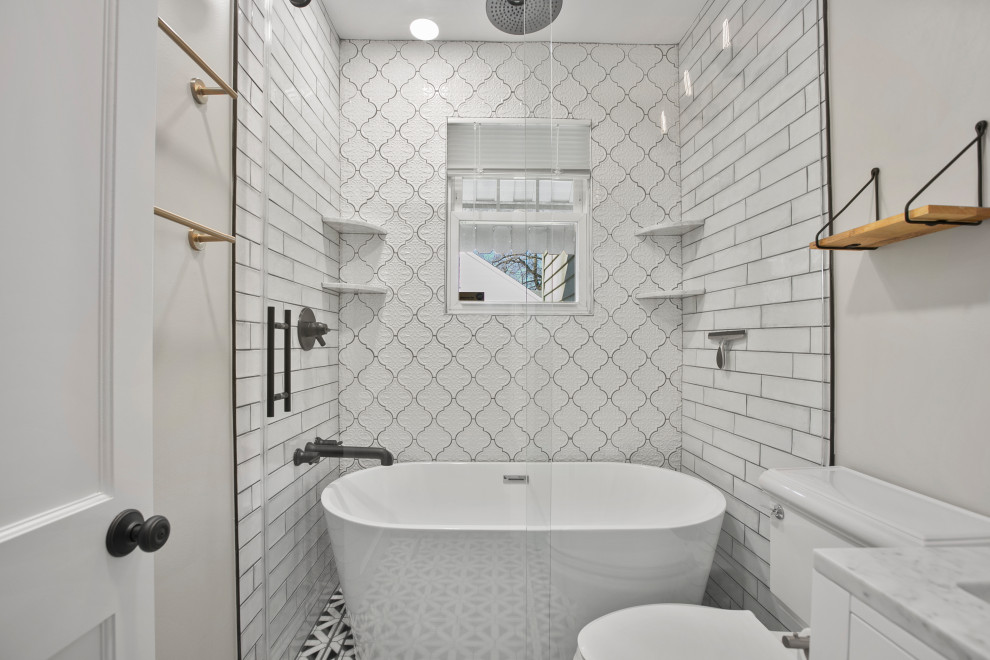 Inspiration for a small midcentury master bathroom in DC Metro with flat-panel cabinets, white cabinets, a freestanding tub, a shower/bathtub combo, a one-piece toilet, white tile, ceramic tile, grey walls, medium hardwood floors, a drop-in sink, engineered quartz benchtops, brown floor, a sliding shower screen, grey benchtops, a single vanity and a freestanding vanity.