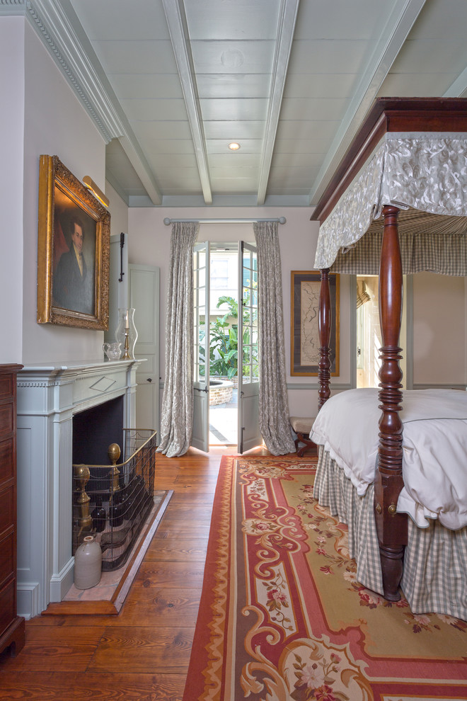 Design ideas for a traditional bedroom in New Orleans with a standard fireplace and orange floor.