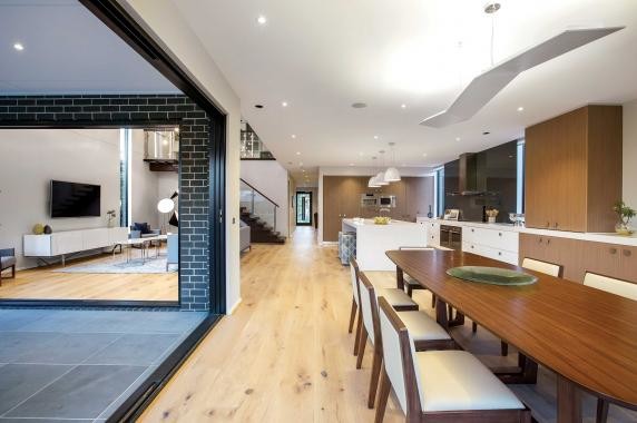 This is an example of a large contemporary open plan dining in Melbourne with grey walls, light hardwood floors and brown floor.