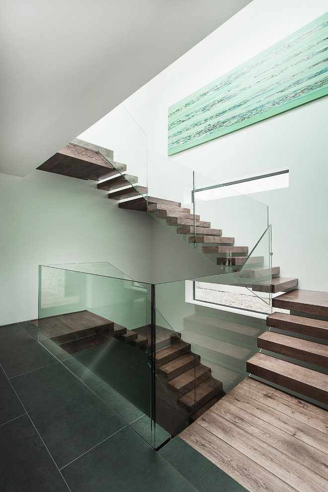 Inspiration for a modern floating staircase in Hampshire with glass railing.
