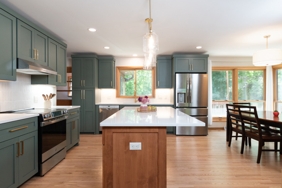 Inspiration for a transitional light wood floor kitchen remodel with shaker cabinets, green cabinets, quartz countertops, white backsplash, ceramic backsplash and an island