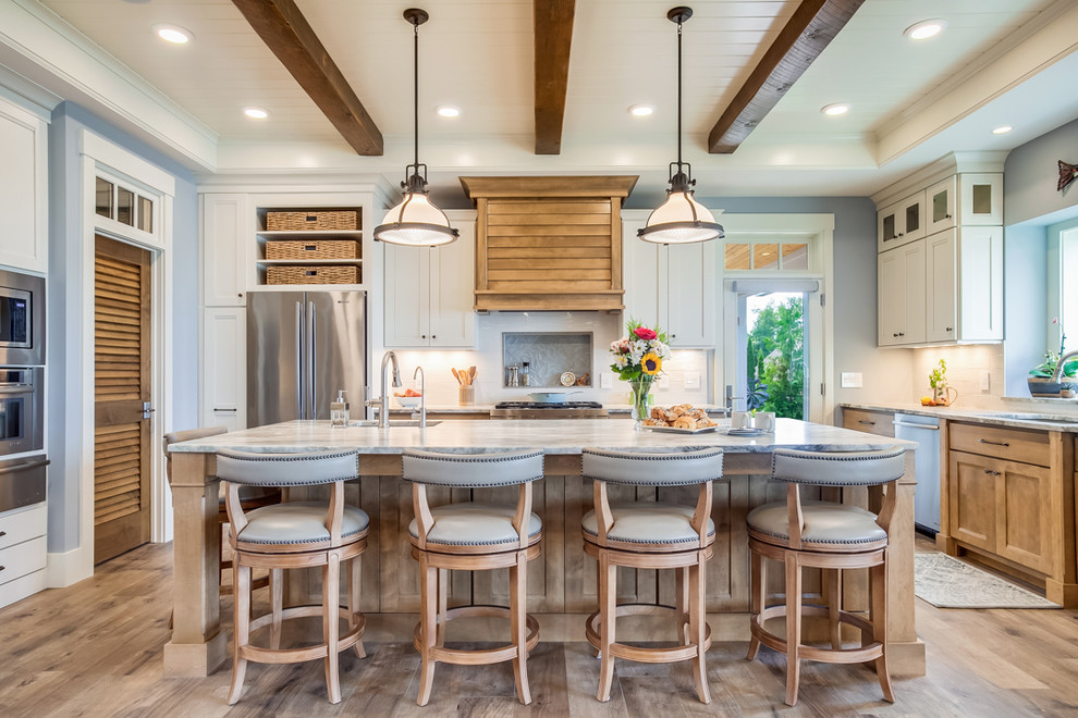 Design ideas for a beach style u-shaped eat-in kitchen in Other with an undermount sink, shaker cabinets, medium wood cabinets, white splashback, stainless steel appliances, medium hardwood floors, with island, brown floor and white benchtop.