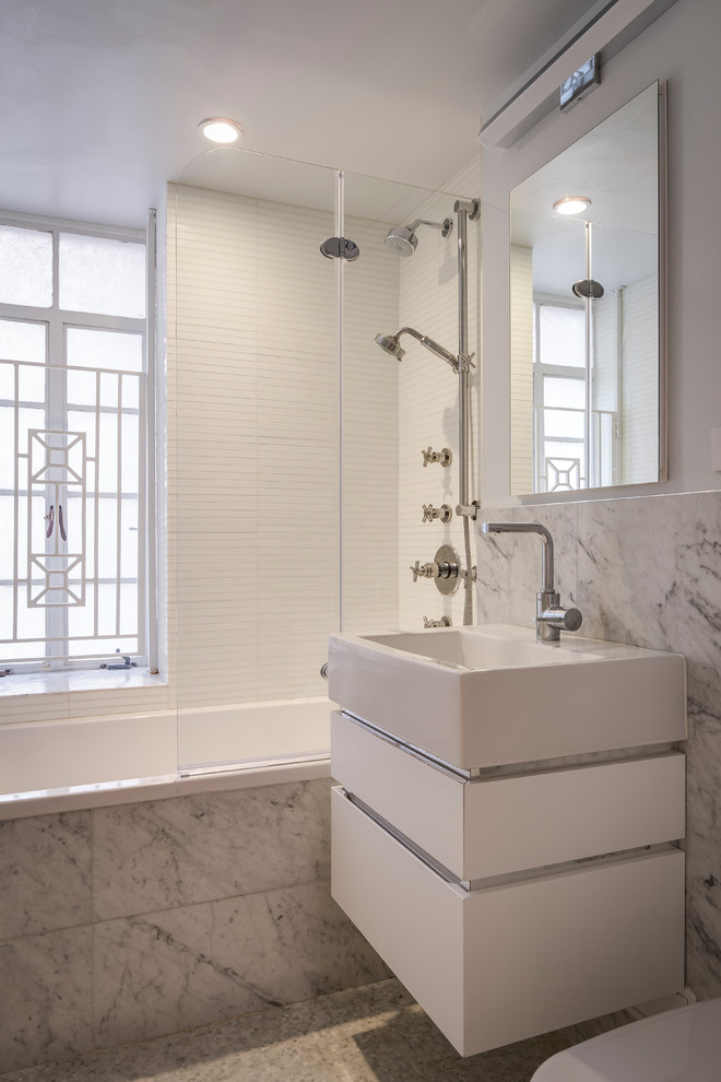 Contemporary 3/4 bathroom in New York with flat-panel cabinets, white cabinets, a drop-in tub, a shower/bathtub combo, gray tile, white tile, grey walls, mosaic tile floors, a console sink, grey floor and an open shower.