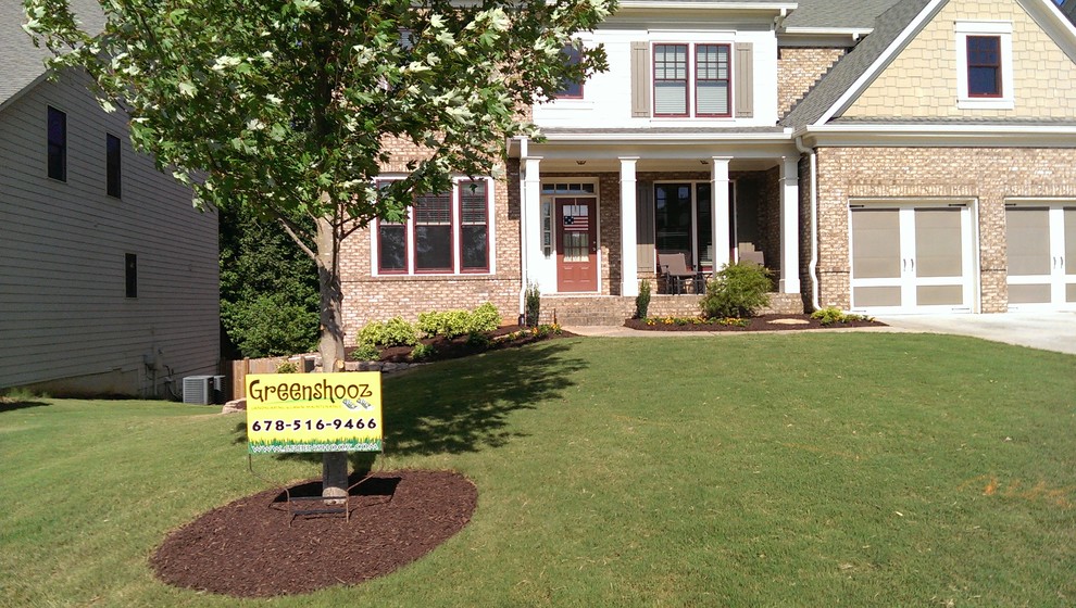 Photo of a traditional front yard garden in Atlanta with a retaining wall and brick pavers.