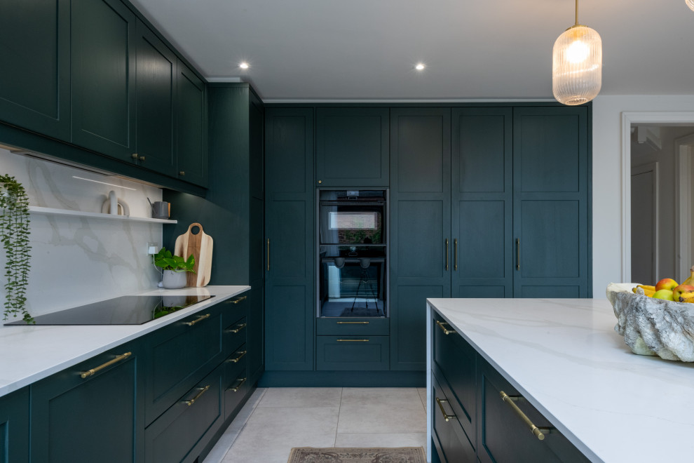Klassische Küche mit Schrankfronten im Shaker-Stil, grünen Schränken, Quarzit-Arbeitsplatte und Kücheninsel in London