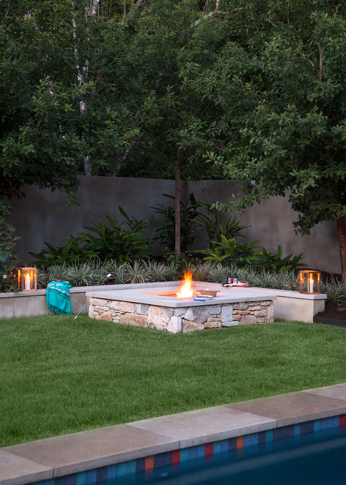 Photo of a transitional backyard partial sun garden in Austin with a fire feature.