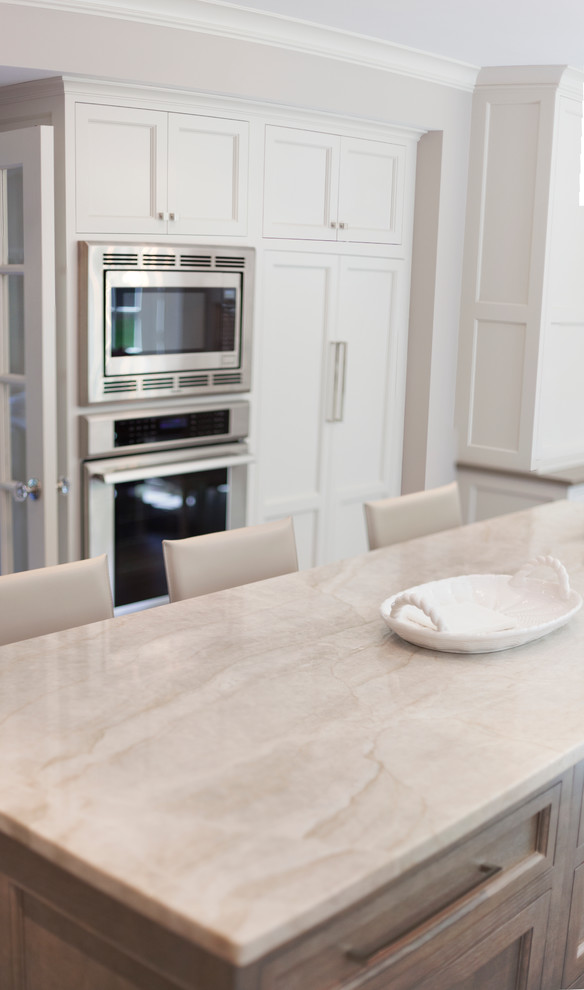 Inspiration for a transitional kitchen remodel in New York with white cabinets, gray backsplash and stainless steel appliances