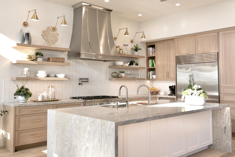Inspiration for a mid-sized coastal galley light wood floor open concept kitchen remodel in Orange County with a double-bowl sink, shaker cabinets, light wood cabinets, marble countertops, white backsplash, marble backsplash, stainless steel appliances, an island and multicolored countertops