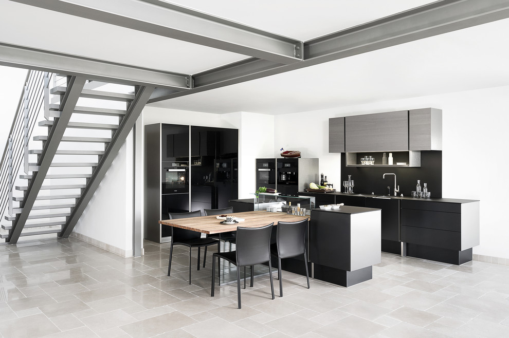 Inspiration for a large contemporary l-shaped kitchen in London with an integrated sink, flat-panel cabinets, black cabinets, glass benchtops, black splashback, glass sheet splashback, black appliances, ceramic floors and with island.