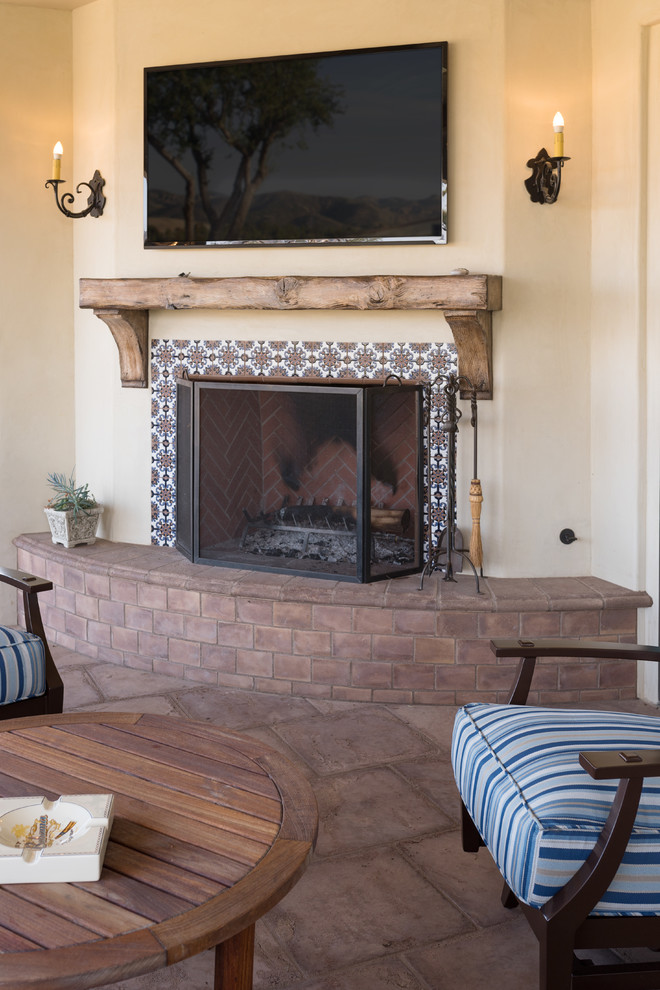 Photo of a mid-sized mediterranean formal open concept living room in Orange County with beige walls, medium hardwood floors, a corner fireplace, a tile fireplace surround and no tv.