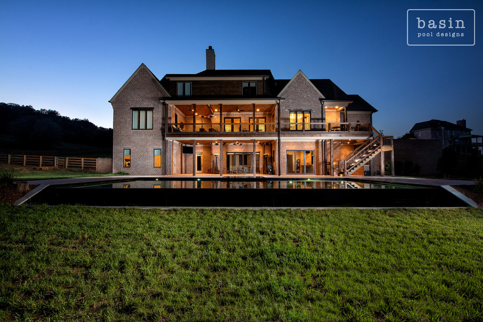 Inspiration for a large transitional backyard stone and custom-shaped infinity hot tub remodel in Nashville