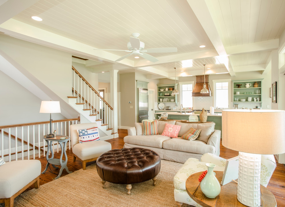 This is an example of a beach style open concept living room in Columbus with beige walls and medium hardwood floors.