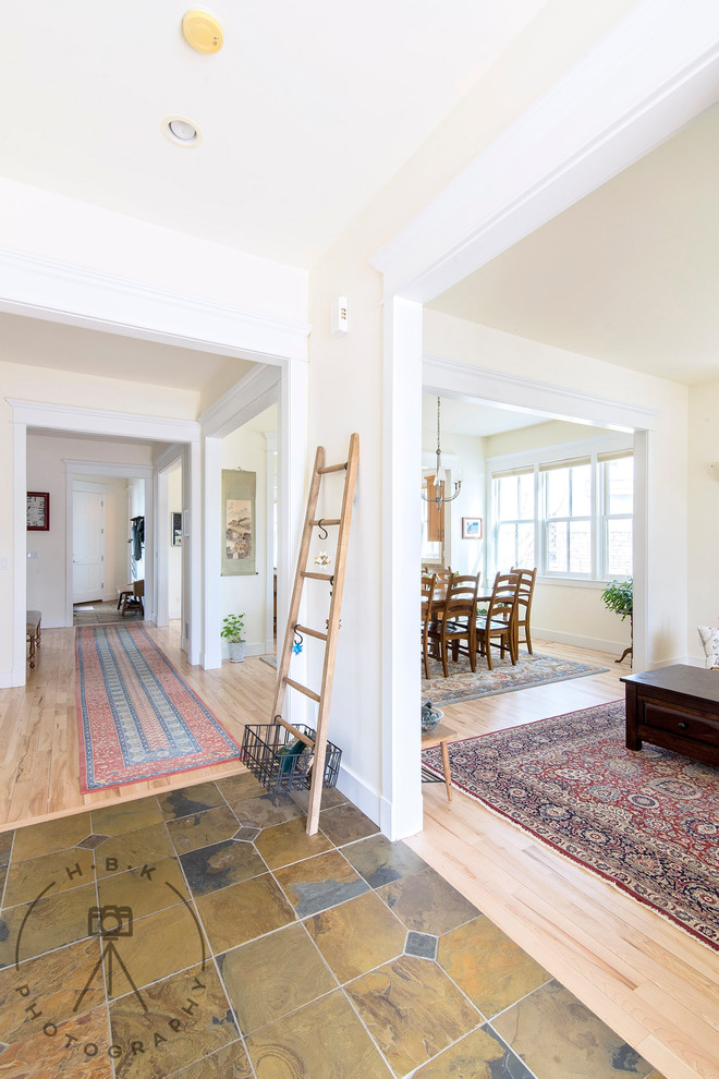 Example of a large ceramic tile and yellow floor entry hall design with white walls