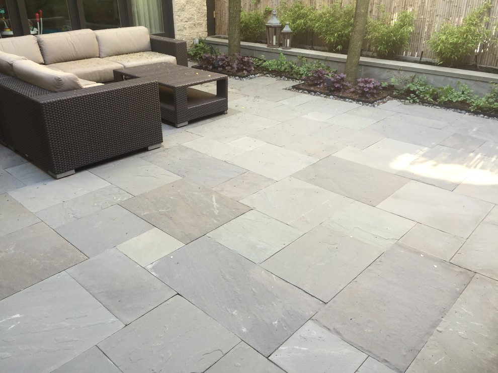 Photo of a mid-sized modern backyard patio in Indianapolis with tile and no cover.