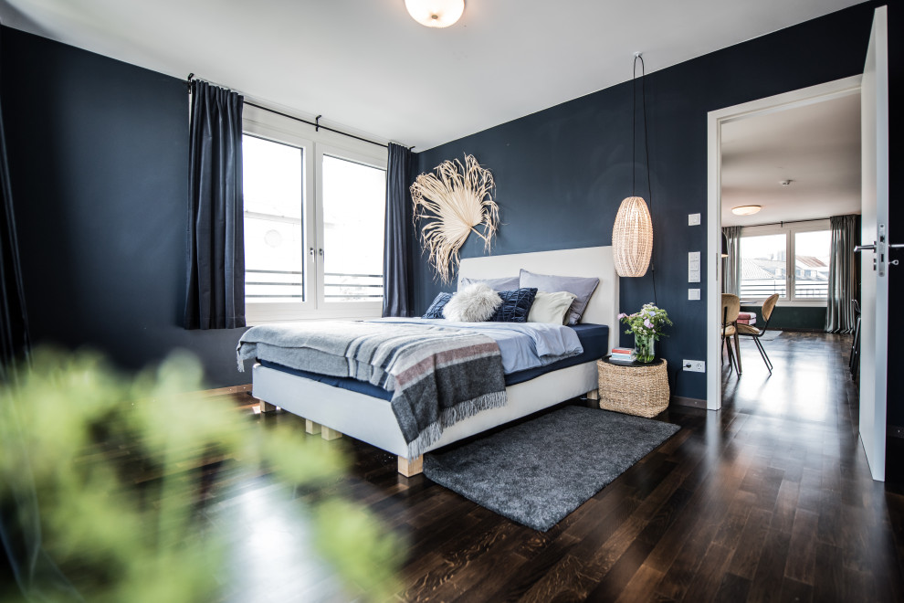 Design ideas for a mid-sized eclectic master bedroom in Munich with blue walls and dark hardwood floors.
