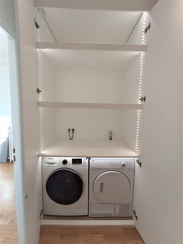 Design ideas for a small contemporary single-wall laundry cupboard in Paris with beaded cabinets, white cabinets, wood worktops, white walls, ceramic flooring, a side by side washer and dryer and white worktops.