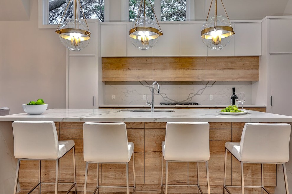 Inspiration for a large scandinavian single-wall light wood floor and beige floor eat-in kitchen remodel in Toronto with a drop-in sink, flat-panel cabinets, light wood cabinets, marble countertops, white backsplash, marble backsplash, stainless steel appliances, an island and white countertops