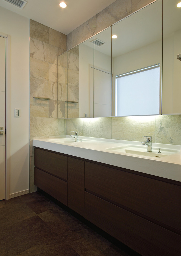 Mid-sized modern powder room in Tokyo with flat-panel cabinets, brown cabinets, gray tile, ceramic tile, grey walls, vinyl floors, an undermount sink, solid surface benchtops and brown floor.