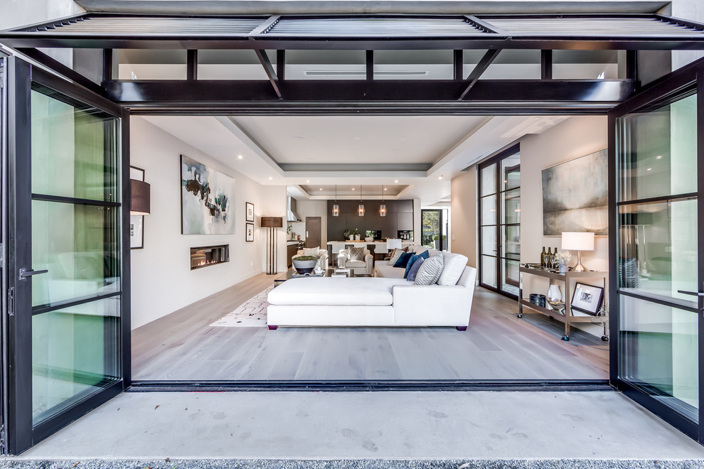 Großes, Offenes Modernes Wohnzimmer mit weißer Wandfarbe, braunem Holzboden, Kamin und TV-Wand in Sacramento