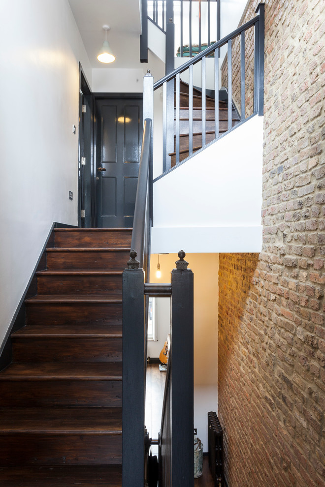 This is an example of a scandinavian wood curved staircase in London with wood risers.