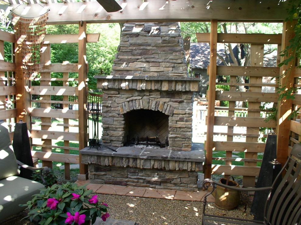 Inspiration for a mid-sized traditional backyard patio in Omaha with gravel, a pergola and with fireplace.