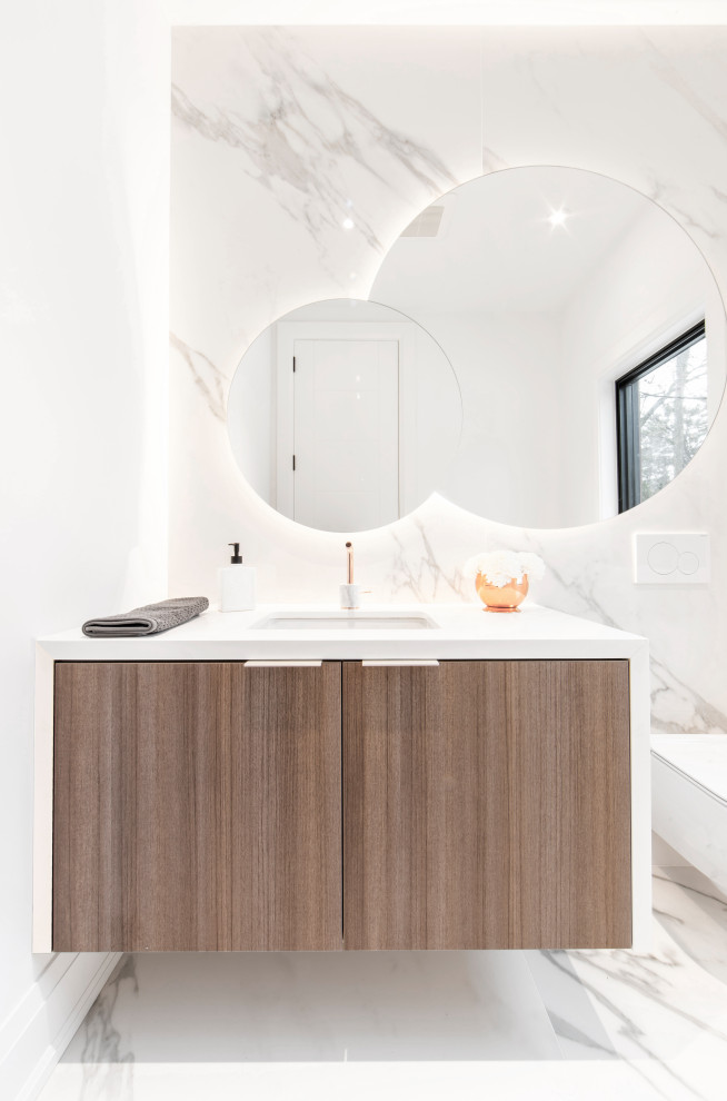 This is an example of an expansive contemporary powder room in Toronto with flat-panel cabinets, medium wood cabinets, a wall-mount toilet, porcelain tile, white walls, porcelain floors, an undermount sink, engineered quartz benchtops, white benchtops, gray tile, grey floor and a floating vanity.