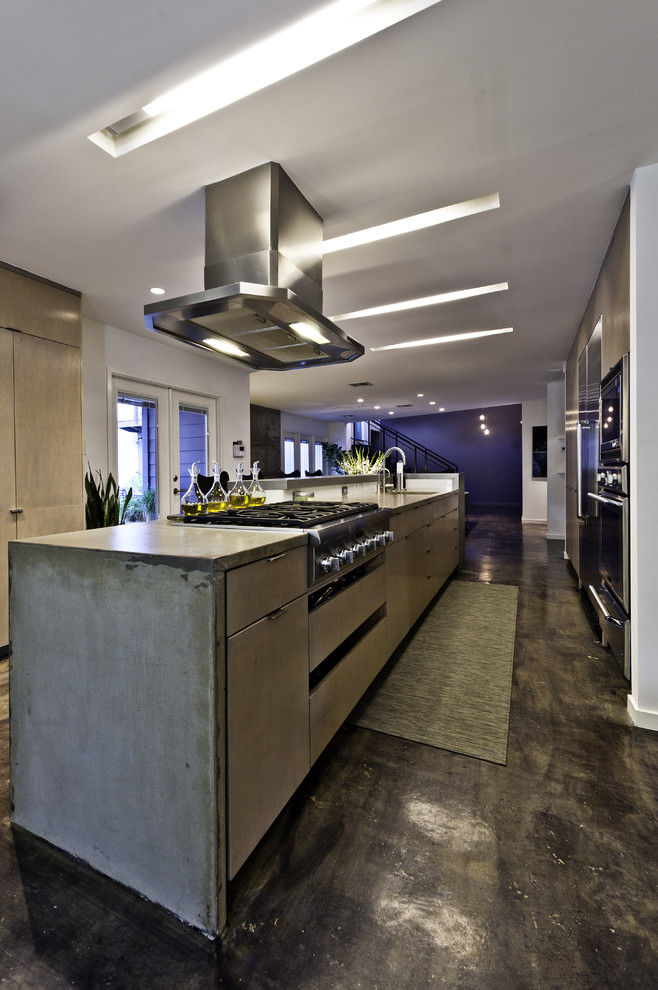 Industrial kitchen in Houston with stainless steel appliances and concrete benchtops.