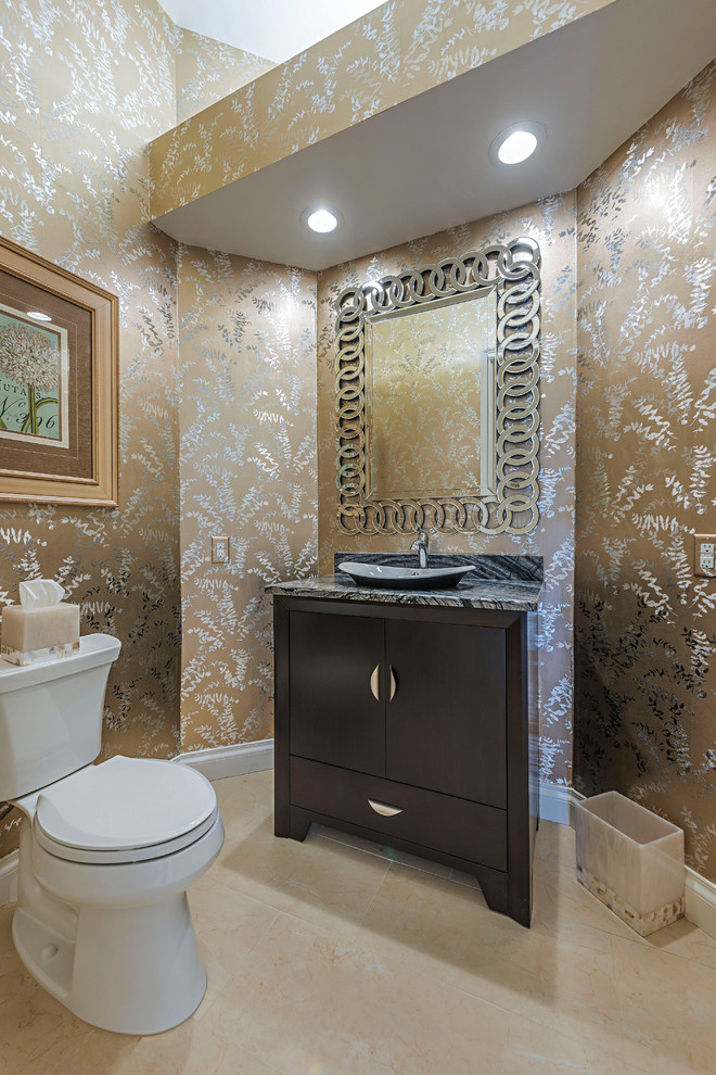 This is an example of a small transitional powder room in Miami with furniture-like cabinets, dark wood cabinets, a one-piece toilet, black and white tile, marble, multi-coloured walls, porcelain floors, a vessel sink, marble benchtops, beige floor and grey benchtops.