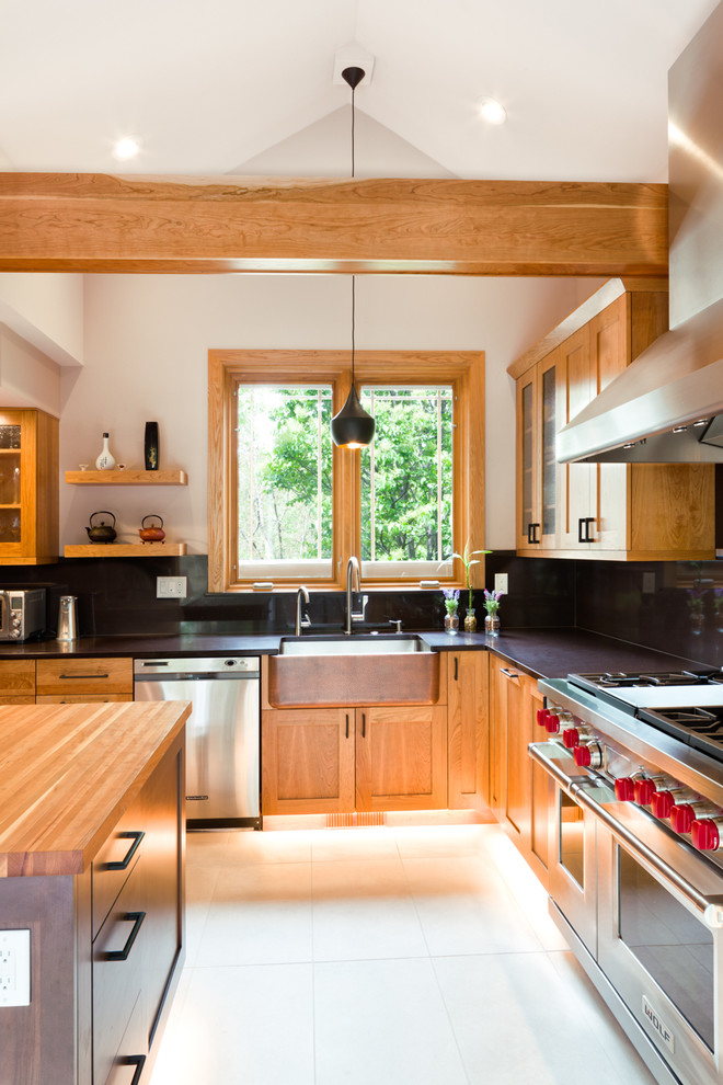 This is an example of a large contemporary l-shaped eat-in kitchen in Denver with a farmhouse sink, recessed-panel cabinets, light wood cabinets, granite benchtops, black splashback, stainless steel appliances, ceramic floors and with island.
