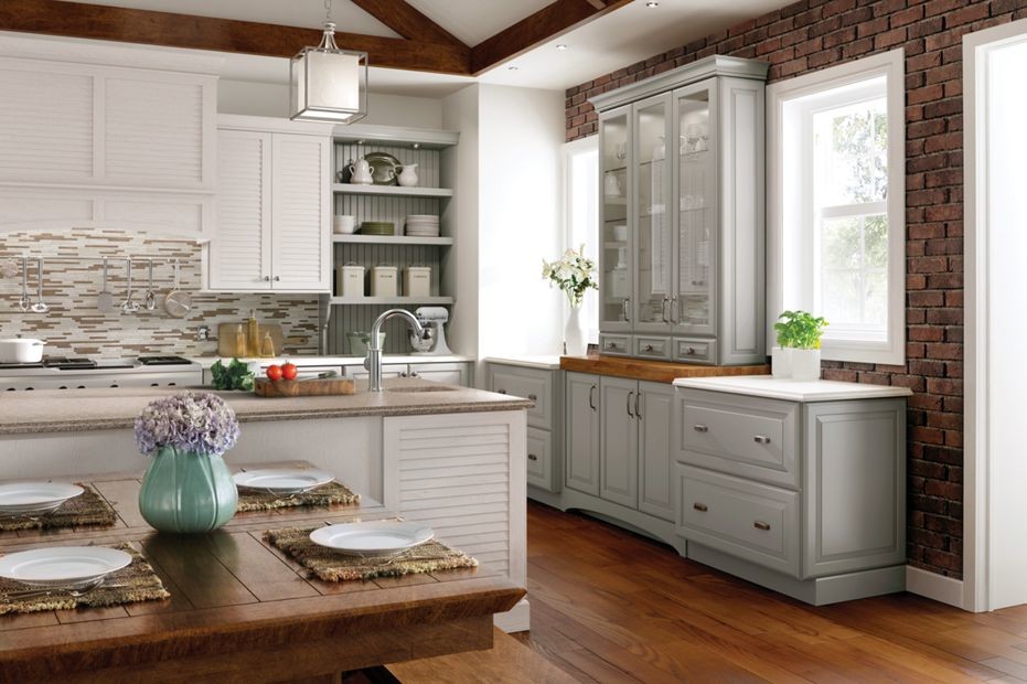 Design ideas for a mid-sized modern galley eat-in kitchen in New Orleans with a drop-in sink, raised-panel cabinets, white cabinets, granite benchtops, multi-coloured splashback, matchstick tile splashback, stainless steel appliances, medium hardwood floors and with island.