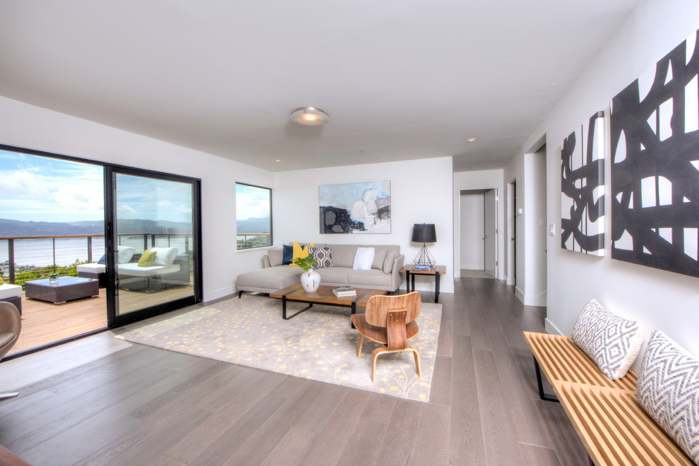 This is an example of a mid-sized beach style enclosed family room in San Francisco with beige walls, light hardwood floors, no tv and brown floor.