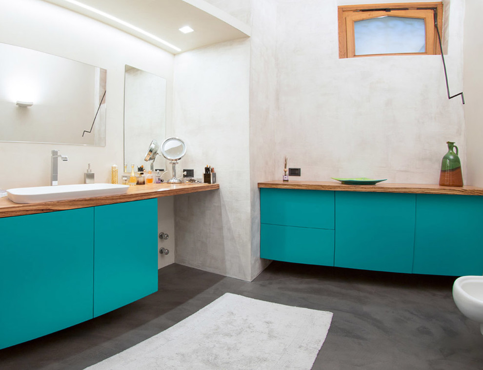This is an example of a mid-sized eclectic master bathroom in Milan with flat-panel cabinets, turquoise cabinets and wood benchtops.