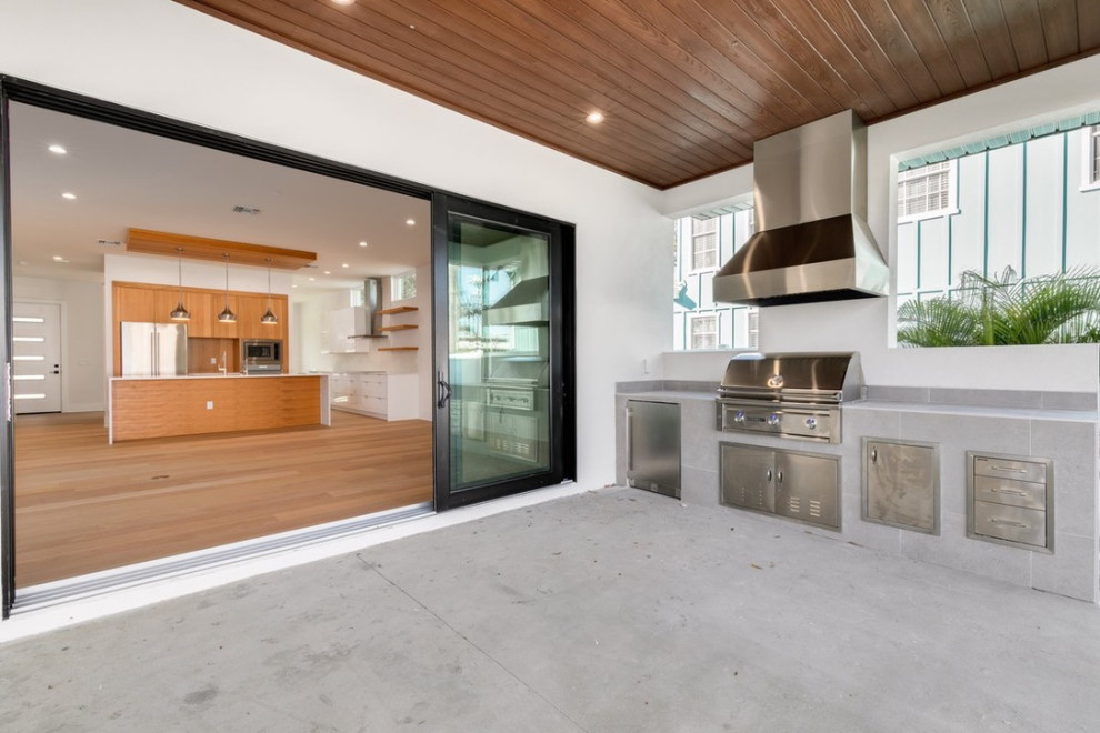 Идея дизайна: двор среднего размера на заднем дворе в стиле модернизм с летней кухней, покрытием из бетонных плит и навесом