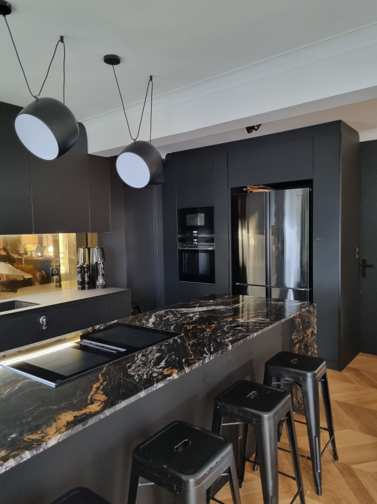 Inspiration for a large contemporary l-shaped eat-in kitchen in Paris with an integrated sink, flat-panel cabinets, black cabinets, solid surface benchtops, metallic splashback, mirror splashback, light hardwood floors, with island and multi-coloured benchtop.