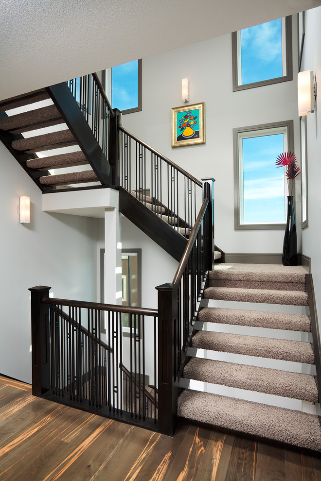 Design ideas for a large contemporary carpeted u-shaped staircase in Calgary with open risers.