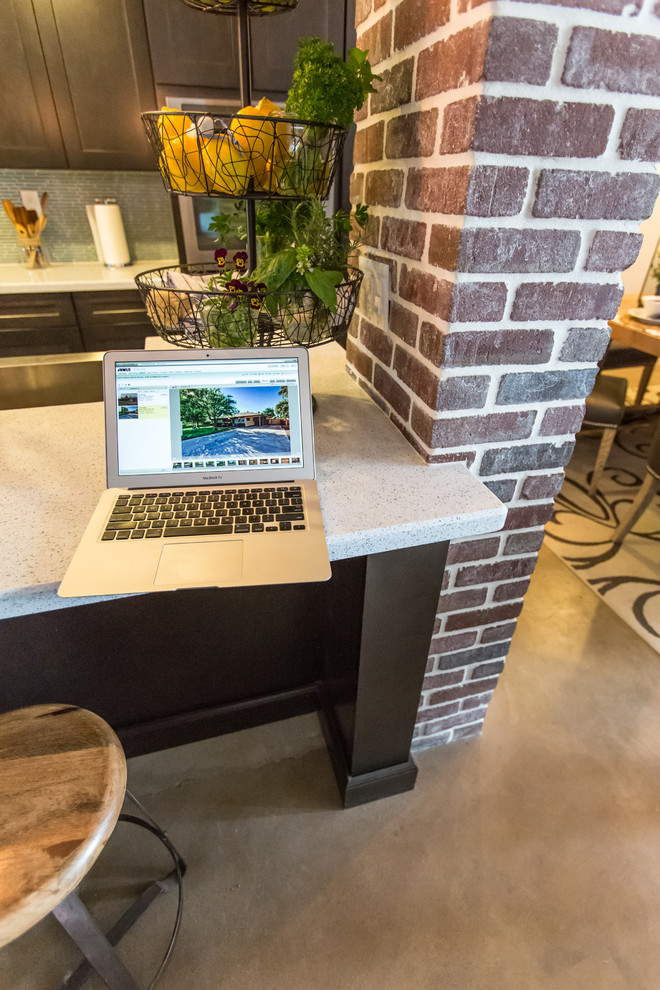 Example of a mid-sized mountain style single-wall concrete floor and gray floor open concept kitchen design in Phoenix with dark wood cabinets, blue backsplash, stainless steel appliances, an island, an undermount sink, shaker cabinets, quartzite countertops and glass tile backsplash