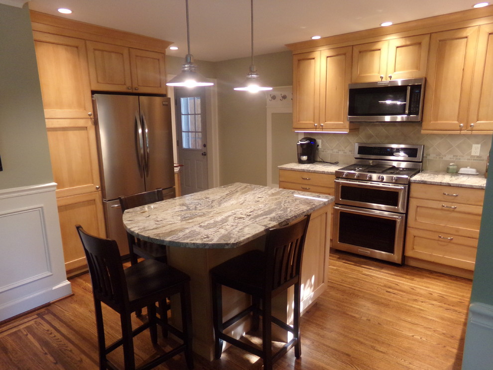 Inspiration for a mid-sized transitional l-shaped medium tone wood floor eat-in kitchen remodel in New York with an undermount sink, raised-panel cabinets, light wood cabinets, granite countertops, beige backsplash, subway tile backsplash, stainless steel appliances and an island