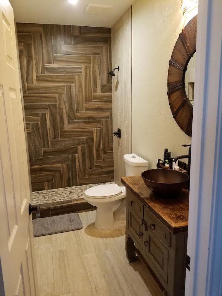 Mid-sized contemporary 3/4 bathroom in Austin with furniture-like cabinets, dark wood cabinets, an alcove shower, a two-piece toilet, brown tile, porcelain tile, beige walls, laminate floors, a vessel sink, wood benchtops, beige floor and a shower curtain.