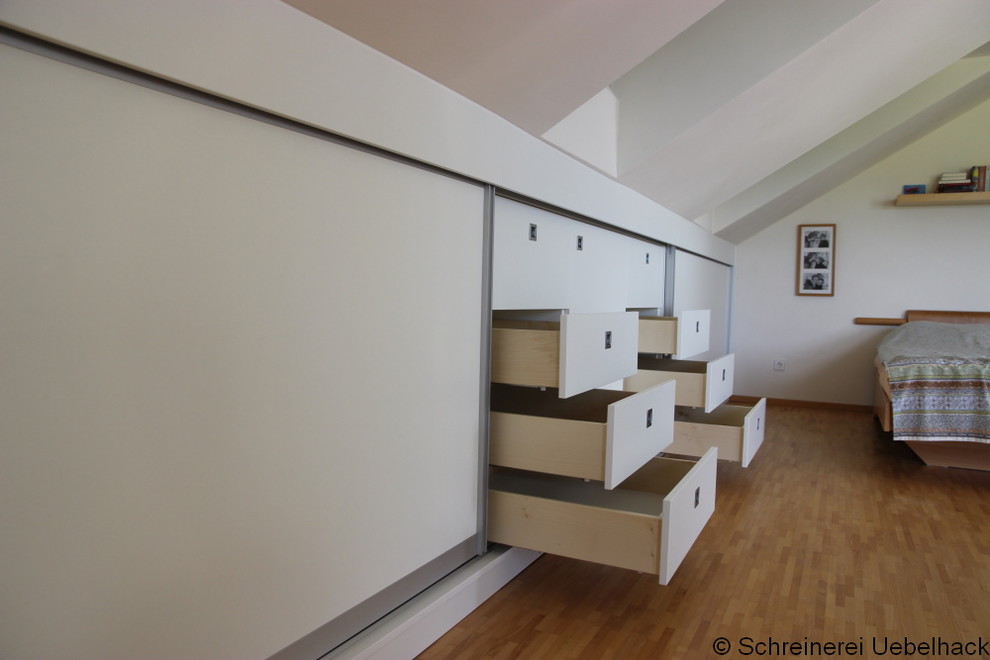Design ideas for a mid-sized modern storage and wardrobe in Hamburg with light hardwood floors.