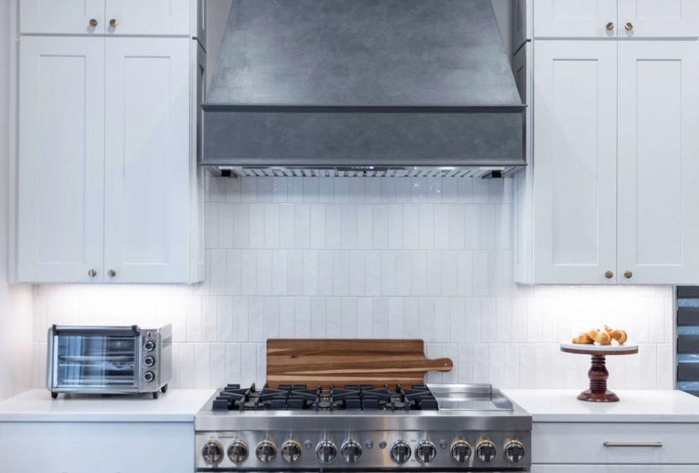 Example of a large transitional u-shaped medium tone wood floor kitchen design in DC Metro with a single-bowl sink, flat-panel cabinets, quartz countertops, white backsplash, porcelain backsplash, stainless steel appliances, an island and white countertops