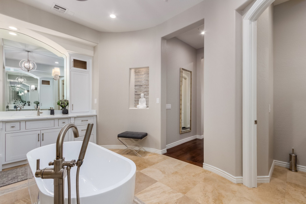 Large transitional master travertine floor and beige floor freestanding bathtub photo in Phoenix with beaded inset cabinets, white cabinets, quartz countertops and white countertops