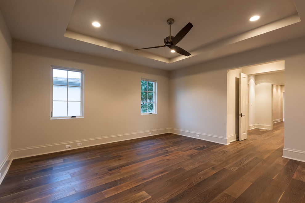 Large transitional medium tone wood floor bedroom photo in Houston with beige walls