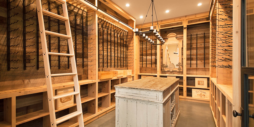 Photo of a large country wine cellar in San Francisco with concrete floors, display racks and grey floor.