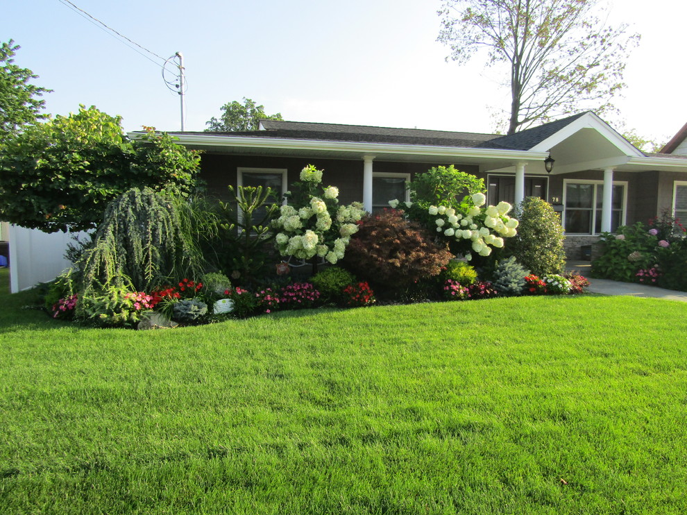 Photo of a mid-sized traditional front yard partial sun garden in New York with a garden path and natural stone pavers.