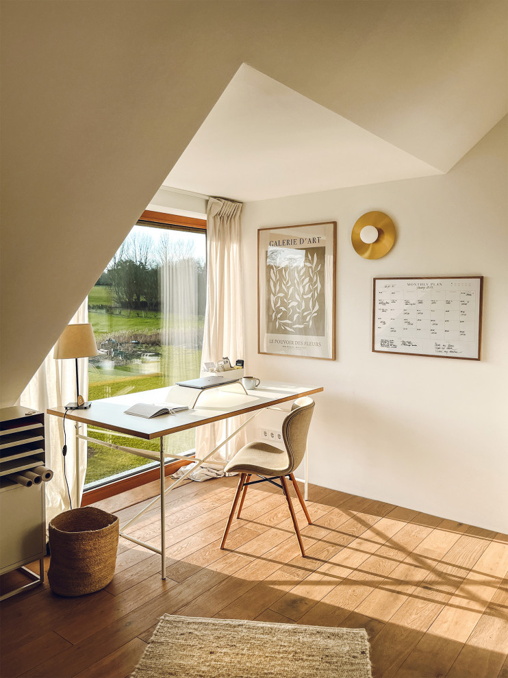 Diseño de estudio escandinavo de tamaño medio con paredes blancas, suelo de madera clara y escritorio independiente